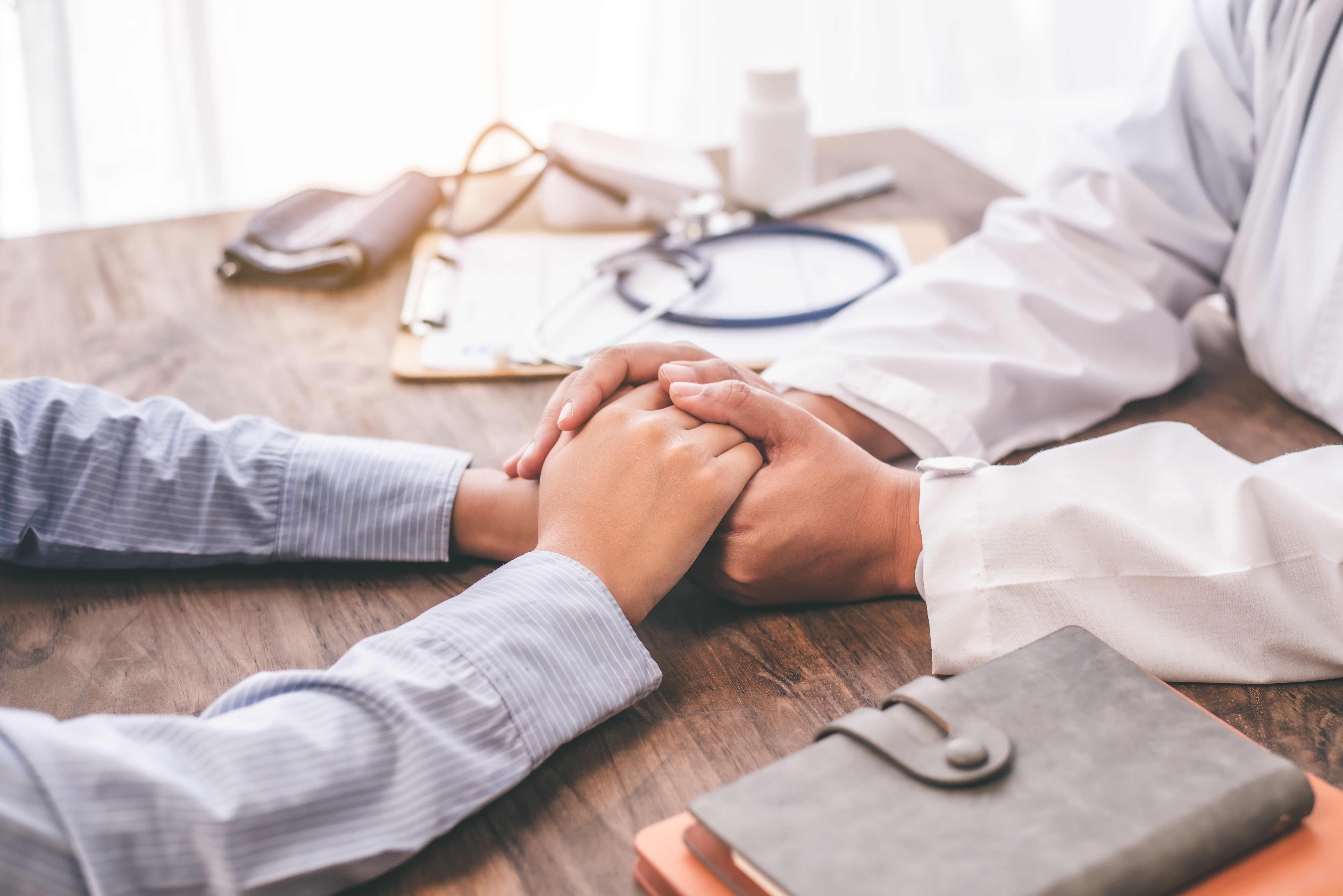 Physician in consultation, comforting a patient